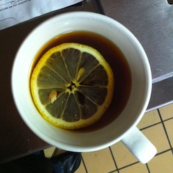 top down view of a mug of tea with a slice of lemon flaoting in it